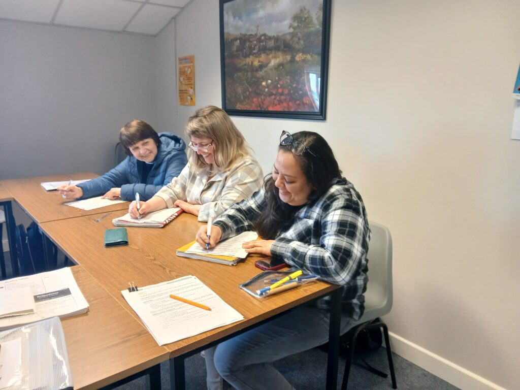 Learners writing at a desk